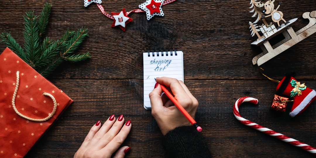 A woman writes a Christmas shopping list